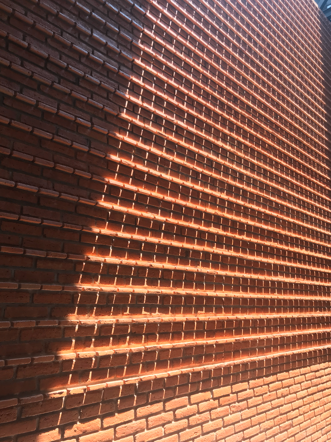 Muro de tabique con luz rasante en fachada o interior